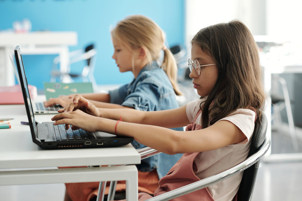 mantenimiento informatico escuelas sevilla Niña con ordenador en el colegio